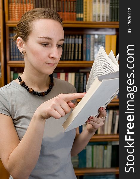 Young woman with a book  in a library