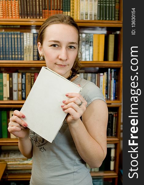 Young woman with a book  in a library