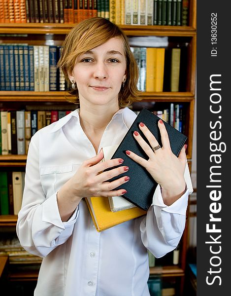 Young woman with a book  in a library