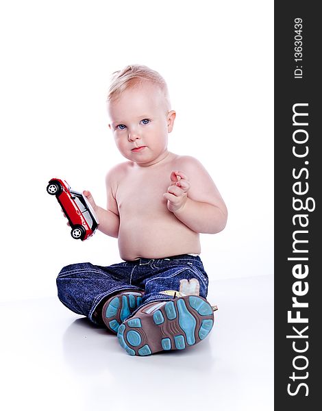 Baby boy playing with red car toy isolated on white. Baby boy playing with red car toy isolated on white