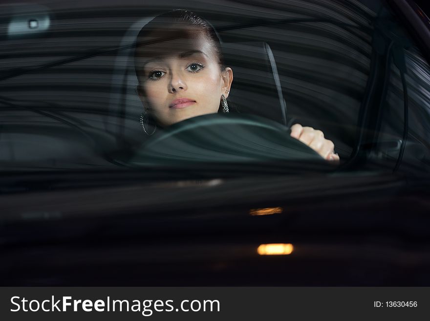 Young beautiful woman driving a car and smiling. Young beautiful woman driving a car and smiling