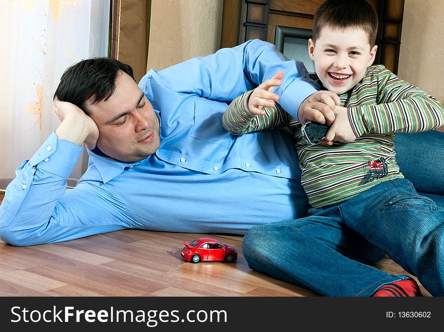 Happy family home: father and son playing on the floor. Happy family home: father and son playing on the floor