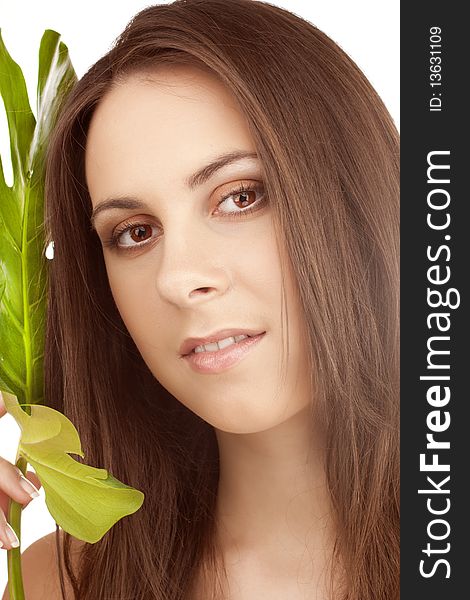 Portrait of young beautiful girl with green leaf