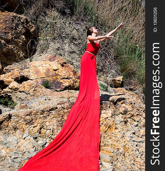 Woman in red dress from material and rocks