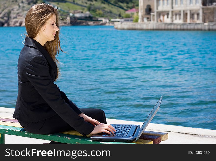 Woman with laptop near the  sea