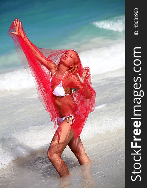 Young woman under red sheer on the beach. Young woman under red sheer on the beach