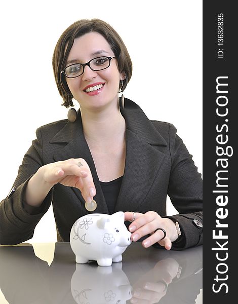 Young business woman iosolated on white putting coins money in piggy bank and representing concept of saving and smart spending money. Young business woman iosolated on white putting coins money in piggy bank and representing concept of saving and smart spending money