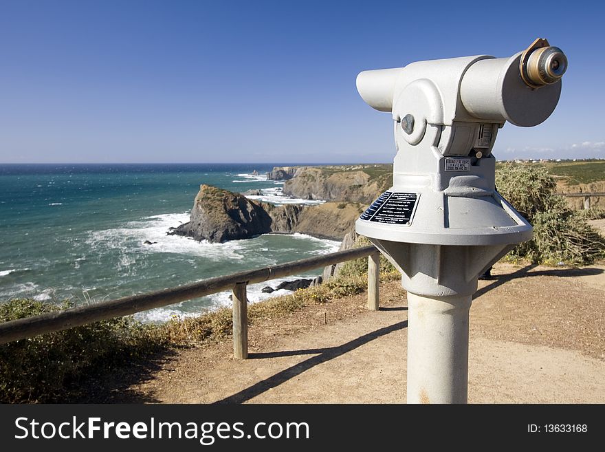 Coin operated telescope in a coastline viewpoint overlooking the ocean (Pay per view concept)