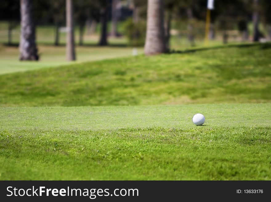 Golf ball on tee in a beautiful green grass golf course,photographed with shallow DOF (Lifestyle concept)