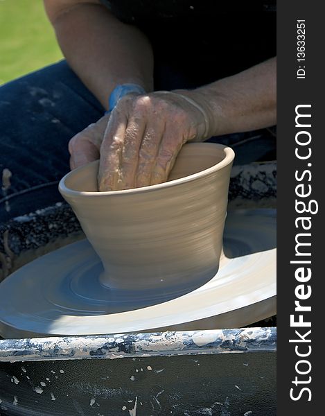 Close up of bowl being formed from wet clay by artist on potter's wheel. Close up of bowl being formed from wet clay by artist on potter's wheel