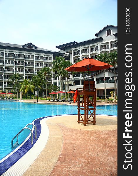 An image showing a lifeguard chair at a poolside of a luxury hotel. An image showing a lifeguard chair at a poolside of a luxury hotel