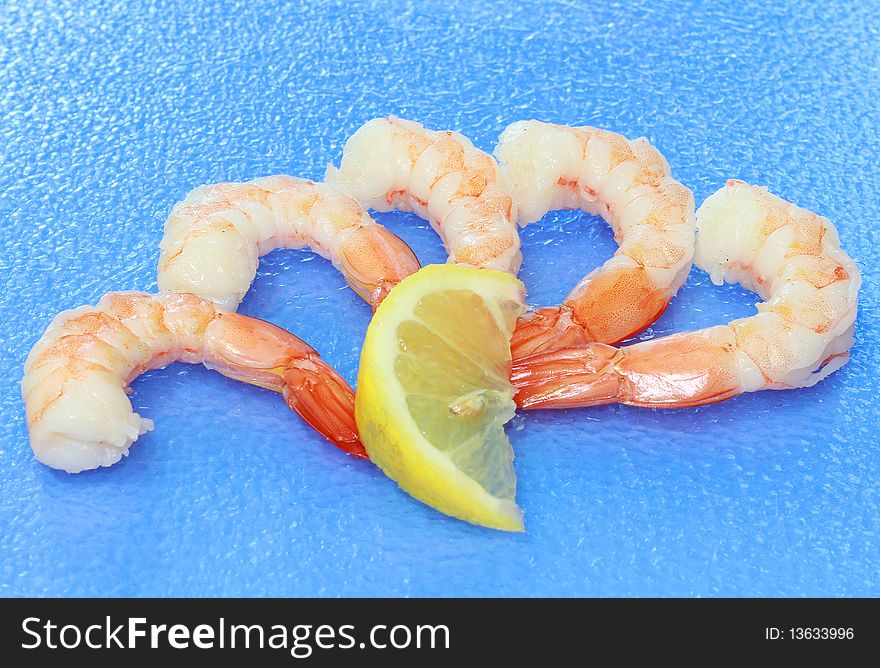 Fresh shrimp on blue background with lemon slice