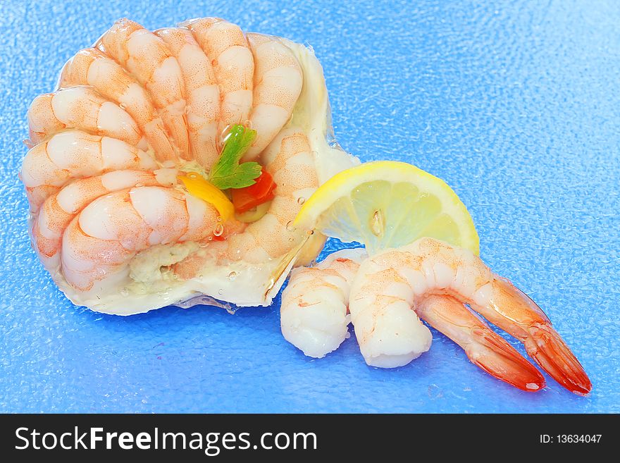 Fresh shrimp on blue background with lemon slice