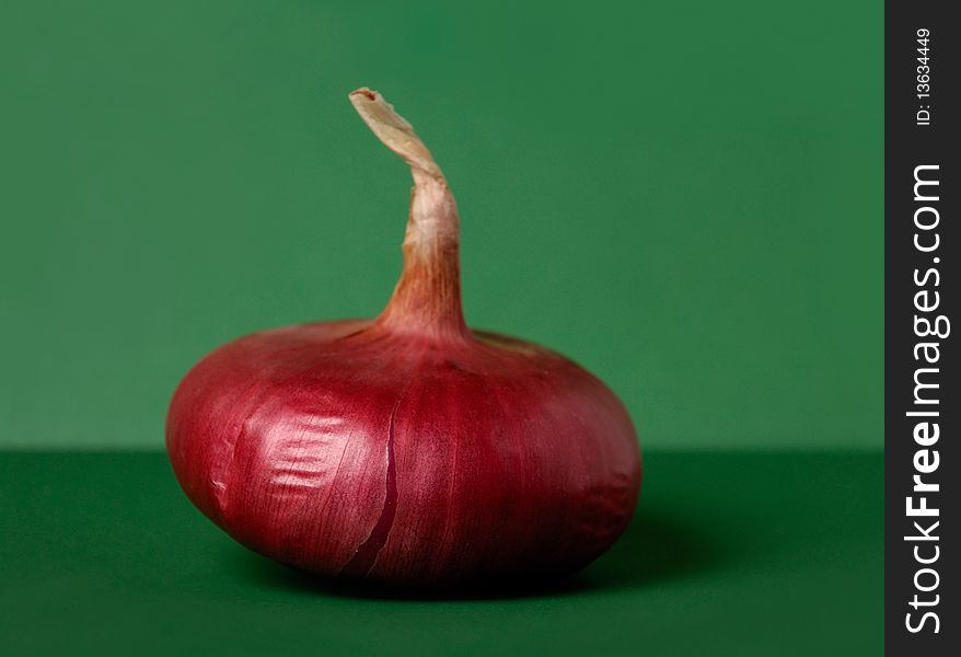 Red onion isolated on green background artistic food still life