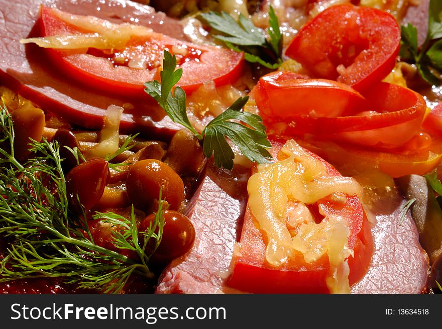 Close up of a pizza with tomatoes and mushrooms