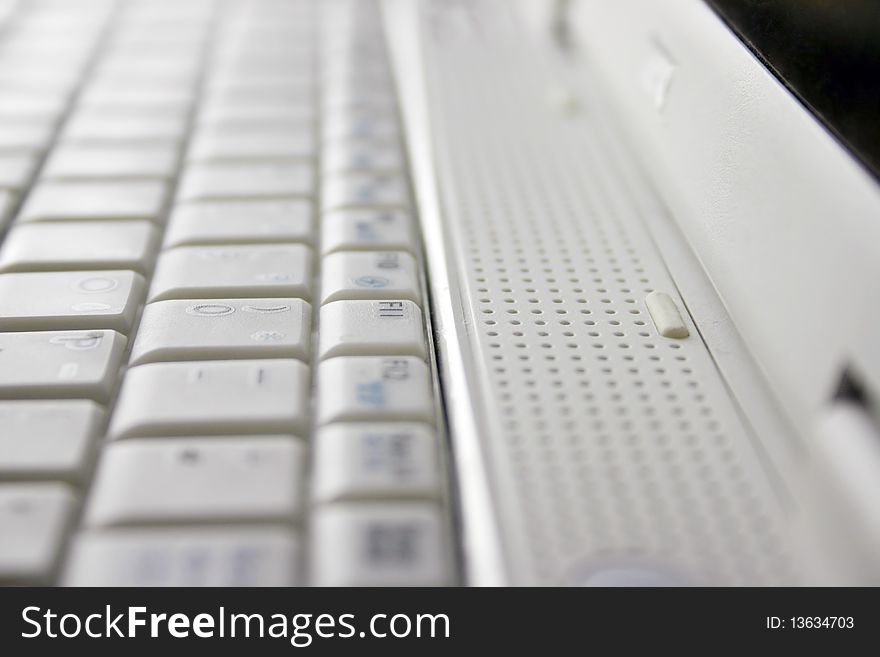 A white laptop computer keyboard view and detail on F11 key. A white laptop computer keyboard view and detail on F11 key.