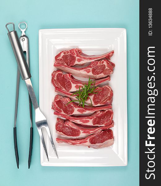 Lamb chops on a plate isolated against a blue background