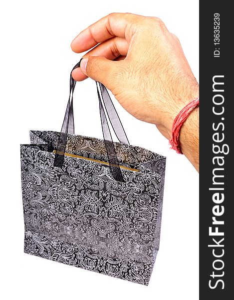 Male hand holding printed shopping bag.