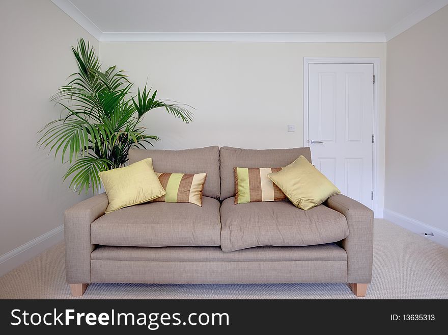 Modern chair within sparsely furnished room with brightly colored scatter cushions. Modern chair within sparsely furnished room with brightly colored scatter cushions