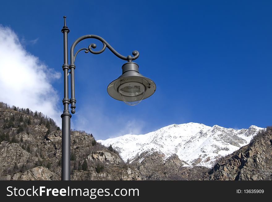 Picture of an old lamp with mountans in foreground. Picture of an old lamp with mountans in foreground