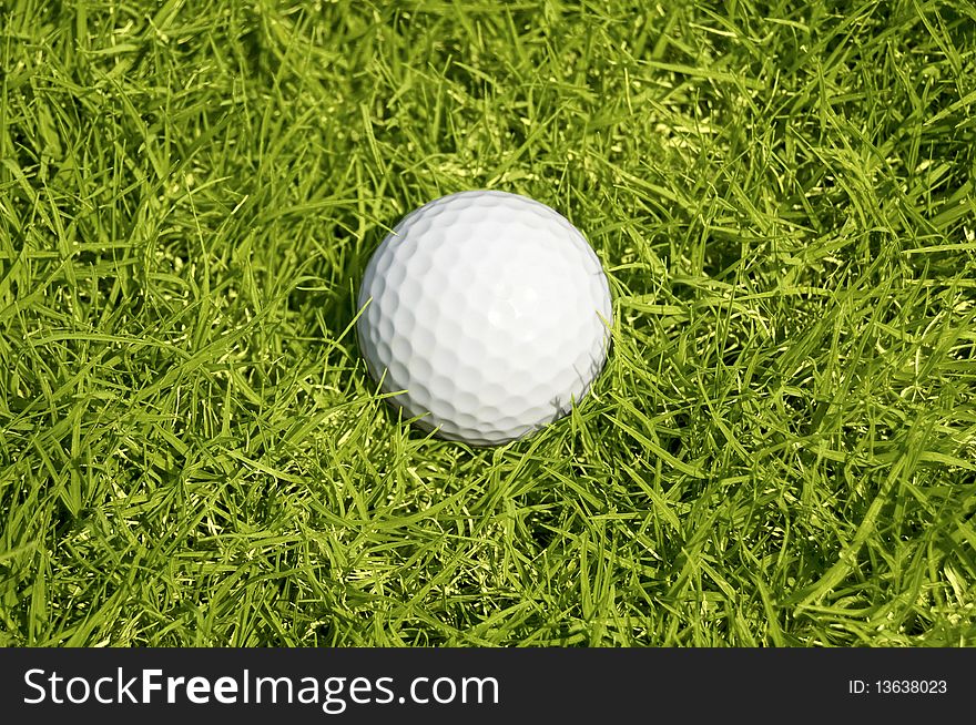 Golfing. A Ball On The Green Grass Background