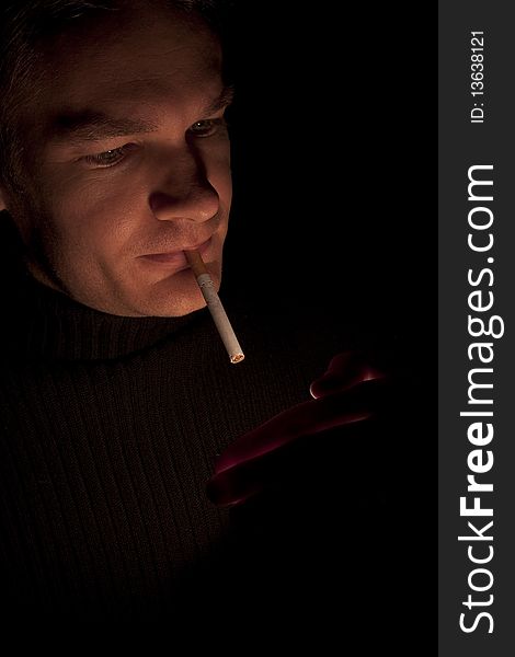 Man lighting up a cigarette at night, low light