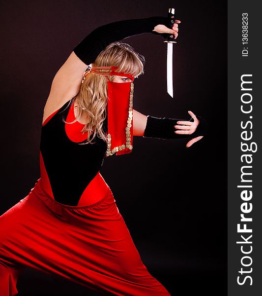 Picture of blond woman holding a dagger and going to fight. Picture of blond woman holding a dagger and going to fight