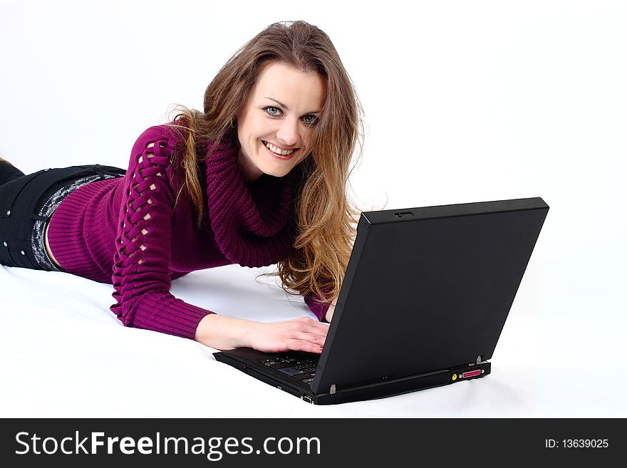 Lying and smiling attractive woman with a laptop on white background