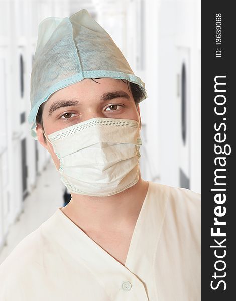 A portrait of a surgeon while an operation is being conducted in the background