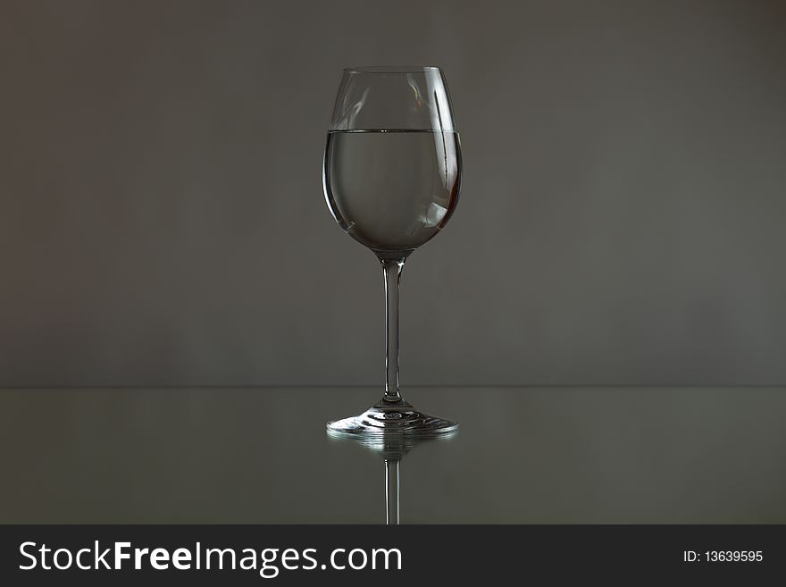 Glass with water on a mirror tablr