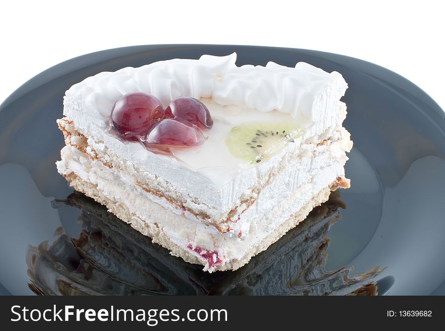 Tasty cake with fruit on black plate