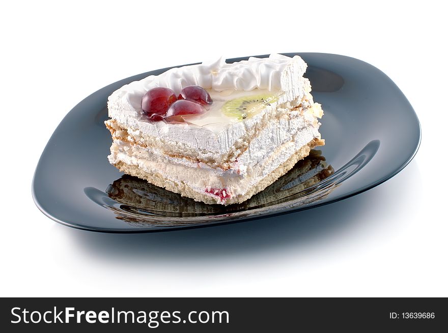 Tasty cake with fruit on black plate