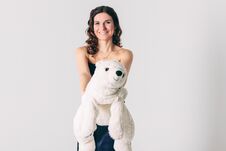 Young Brunette Woman In Evening Dress With Polar Bear Toy Royalty Free Stock Images