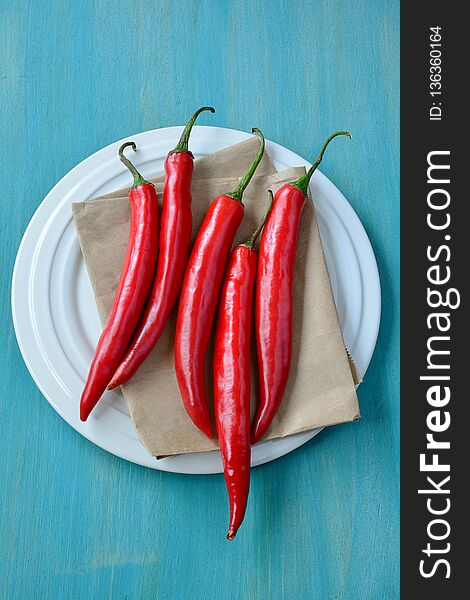 Red chili on dish and wooden background.