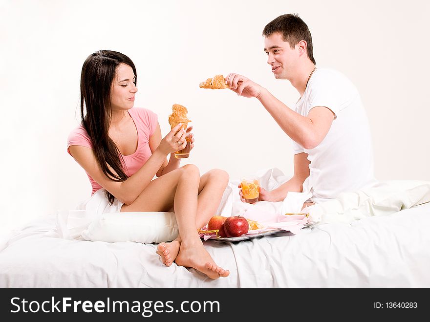 Young couple having breakfast in bed.