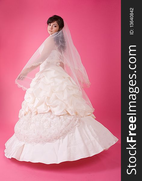 Studio portrait of a happy bride on a pink background