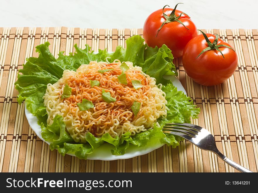 Dish of noodles on lettuce leaf