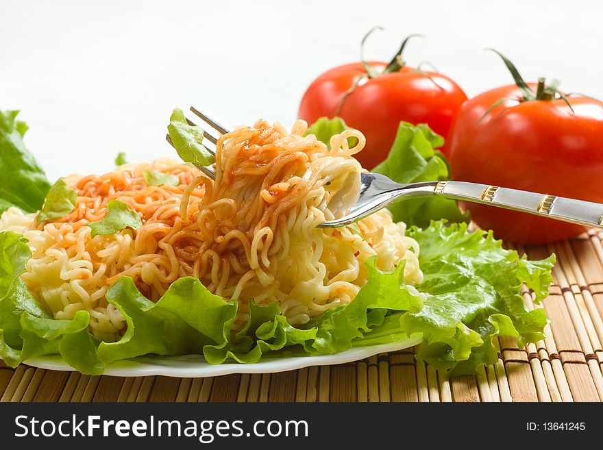 Dish of noodles on lettuce leaf