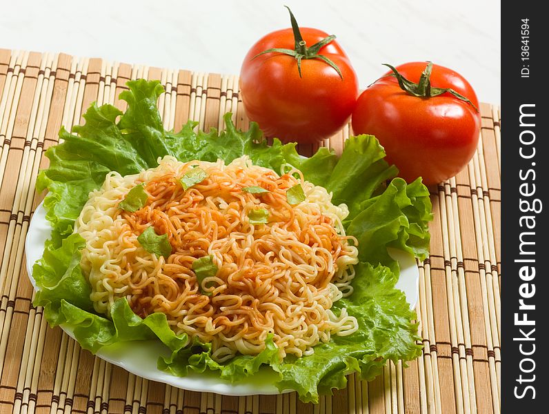 Dish of noodles on lettuce leaf