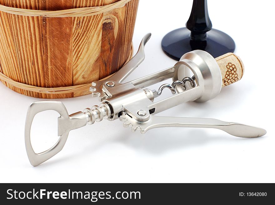 corkscrew with a wooden stopper and a wine cask close up. corkscrew with a wooden stopper and a wine cask close up