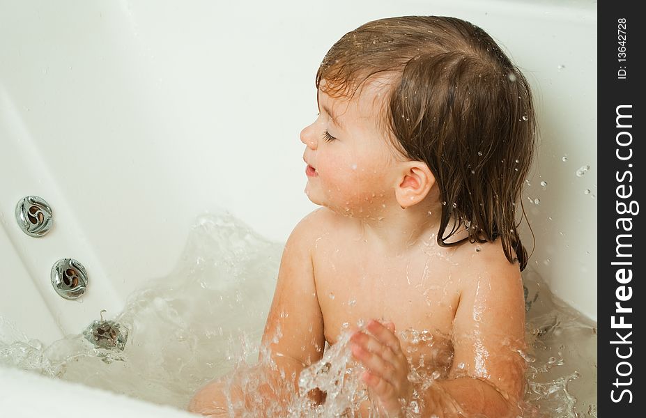 Cute little girl splashing water in a bath