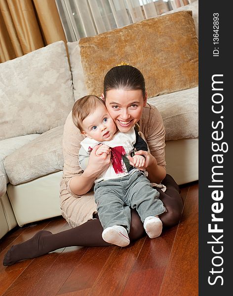 Happy young beautiful mother with her little son in home interior. Happy young beautiful mother with her little son in home interior