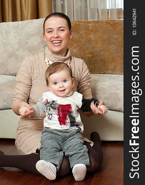 Happy young beautiful mother with her little son in home interior