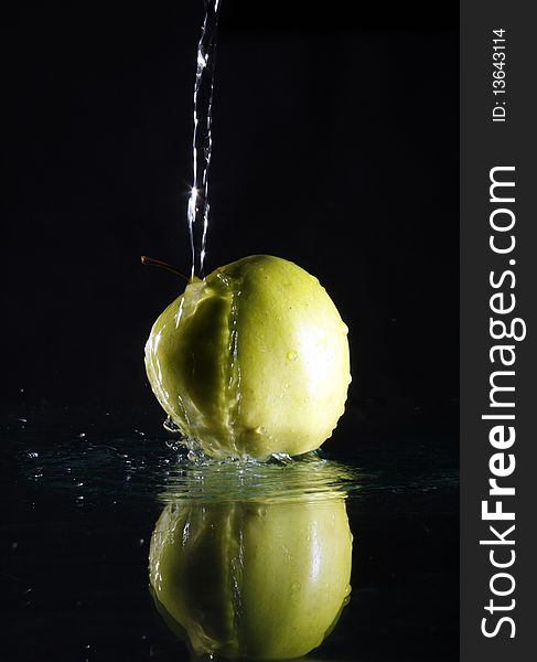 Green apple on black background with water. Green apple on black background with water