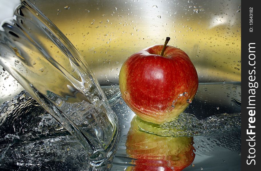 Water splashes and a yellow and red apple. Water splashes and a yellow and red apple