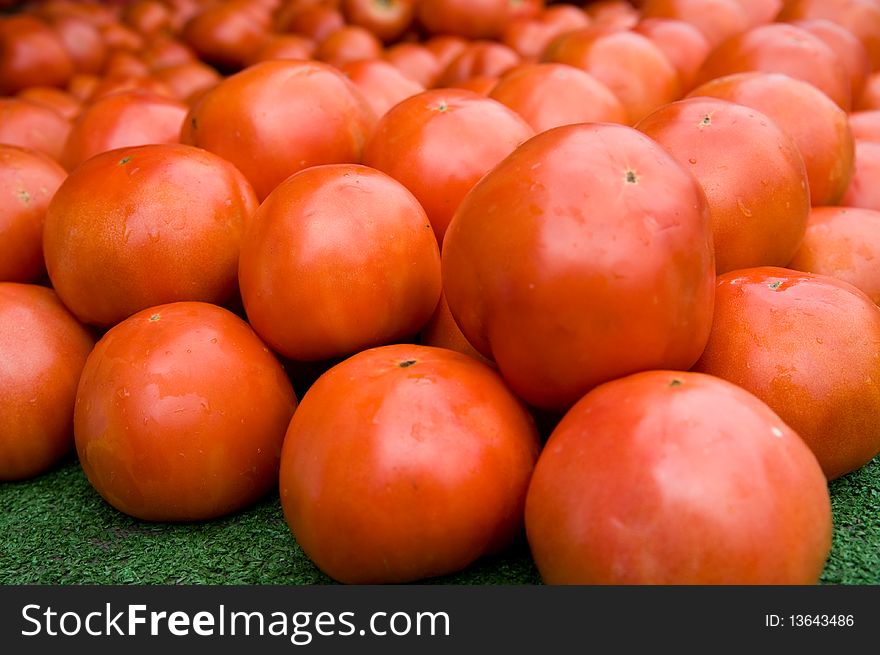 A stack of fresh tomatoes for sale at a farmer's market. A stack of fresh tomatoes for sale at a farmer's market.
