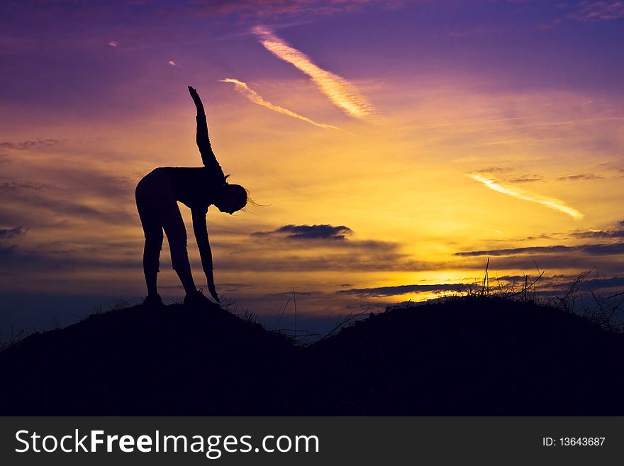 Sporty, slim girl stretching in the sunset. Sporty, slim girl stretching in the sunset.