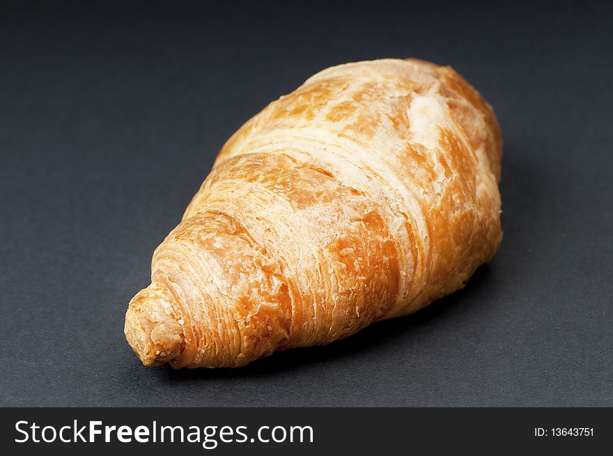 Single fresh croissant, studio shot