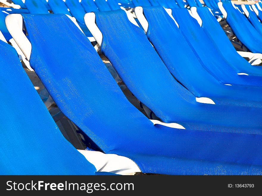 Blue and white plastic lounges near pool