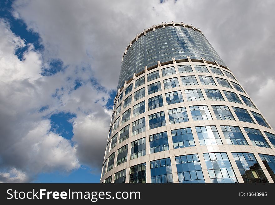 Modern glass bussines center under blue sky with clouds in summer